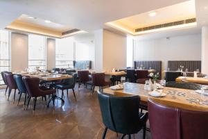 a restaurant with tables and chairs in a room at Marine Inn Hotel in Cochin