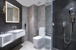 a bathroom with a toilet and a sink and a shower at Marine Inn Hotel in Cochin