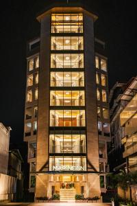 a tall building with a sign on it at night at Marine Inn Hotel in Cochin