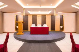 a conference room with a red table and a podium at Marine Inn Hotel in Cochin