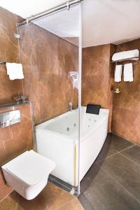 La salle de bains est pourvue d'une baignoire et de toilettes. dans l'établissement Marine Inn Hotel, à Cochin