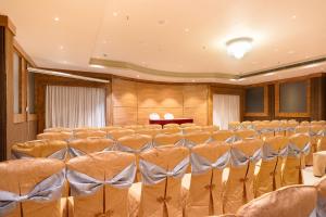 a conference room with rows of chairs and a podium at Marine Inn Hotel in Cochin