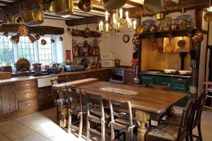 cocina grande con mesa de madera y sillas en Hagg Hill Hall en Wingerworth