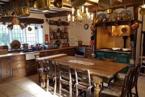 a large kitchen with a wooden table and chairs at Hagg Hill Hall in Wingerworth