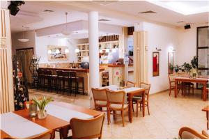 a restaurant with tables and chairs and a kitchen at Hotel Piast in Cedynia
