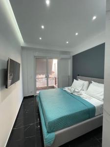a bedroom with a bed with a blue comforter at ATH-Brand new 2bedroom apartment in Athens