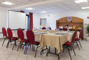 a conference room with a long table and chairs at The Originals City, Hôtel Paris Sud, Orly-Draveil in Draveil