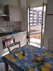 una cucina con tavolo e ciotola di frutta di Casa vacanza G.S. Holiday a Catania
