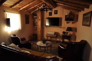a living room with a couch and chairs and a tv at Casa Pradillo in Añavieja