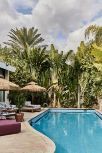 een zwembad in een resort met palmbomen bij Villa Balfour in Eilat