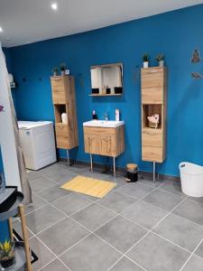 uma casa de banho com um lavatório e uma parede azul em chez Aline em Calais