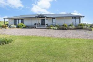 a house with a large yard in front of it at London Bridge Holiday Home in Port Campbell