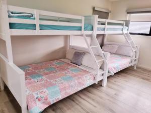 a bedroom with two bunk beds and a bed at London Bridge Holiday Home in Port Campbell