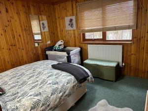 a bedroom with a bed and a table and a chair at Craiglea Cottage, self catering highland cottage. in Fort William