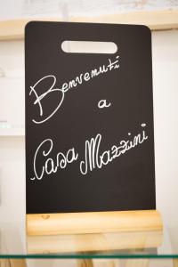 a chalkboard sign on top of a glass table at Casa Mazzini in Verona