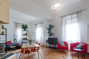 een woonkamer met rode stoelen en een tafel bij Casa Mazzini in Verona