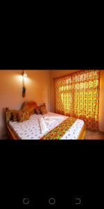 a bedroom with a large bed and a window at ZIMBE HOST Apartment in Arusha