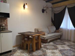ein Wohnzimmer mit einem Tisch und einem Sofa in der Unterkunft Уютный котедж "Hatynka" in Jablunyzja
