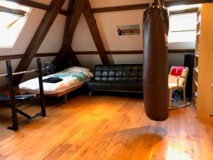 a living room with a black leather couch and wooden floors at Monumental villa at the forest close to Haarlem and the beach in Heemstede