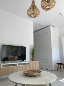 een woonkamer met een tafel en een televisie bij The Palm Apartment Karpathos in Karpathos