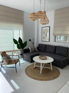 een woonkamer met een bank en een tafel bij The Palm Apartment Karpathos in Karpathos