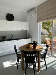 una cucina con tavolo e sedie in legno di The Palm Apartment Karpathos a Karpathos