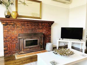 Μια τηλεόραση ή/και κέντρο ψυχαγωγίας στο Daisy Cottage on Duke 2BR