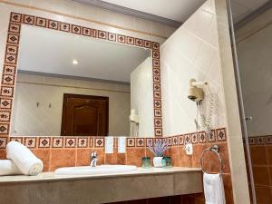 baño con lavabo y espejo grande en Beatriz Charming Hostal en Torremolinos
