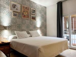 a bedroom with a large bed and a wall with pictures at Beatriz Charming Hostal in Torremolinos