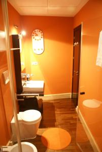 Precioso Apartamento - Casco Antiguo de Talavera في تالافيرا دي لا رينا: حمام برتقالي مع مرحاض ومغسلة