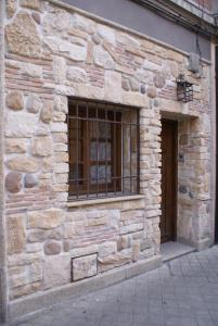 Precioso Apartamento - Casco Antiguo de Talavera في تالافيرا دي لا رينا: مبنى حجري مع نافذة وباب