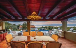 una sala da pranzo con tavolo e sedie su un patio di Gorgeous Apartment In Smrika With Wifi a Šmrika