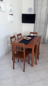 un tavolo in legno con sedie e un piatto di cibo sopra di Appartamento24maggio a Vieste