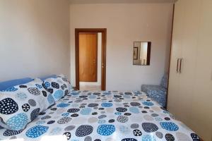un letto con cuscini bianchi e blu di Appartamento24maggio a Vieste