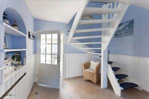 uma escada branca num quarto com paredes azuis em Landhaus Kranichblick em Wieck