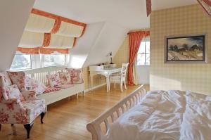um quarto com uma cama, um sofá e uma mesa em Landhaus Kranichblick em Wieck