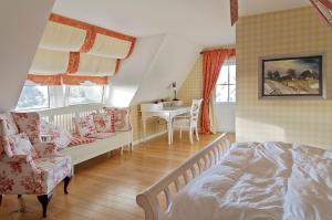 a bedroom with a bed and a couch and a table at Landhaus Kranichblick in Wieck