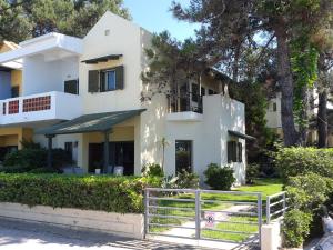 a white house with a fence in front of it at Villa Sofias in Pefkochori