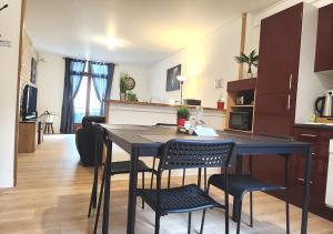 a kitchen and living room with a table and chairs at "Colbert Triplex" 3 chambres - Balcon - Patio - Cathédrale in Tours