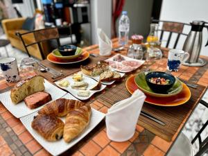 een tafel met borden met eten en gebak bij Les Suites Champenoises in Reims