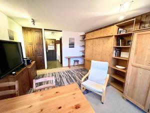 a living room with a tv and a table and chairs at Cosy Studio for 5 near ski lift, Les Gentianes in Les Collons
