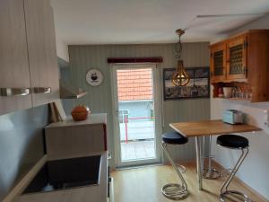 eine Küche mit einem Tisch und 2 Hockern in der Unterkunft BlackforestBike&HikeHouse in Baiersbronn