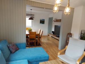 een woonkamer met een blauwe bank en een tafel bij BlackforestBike&HikeHouse in Baiersbronn
