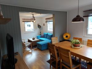 a living room with a table and a blue couch at BlackforestBike&HikeHouse in Baiersbronn