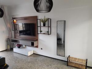 sala de estar con TV y espejo en Edifício Guanaces, en Fortaleza