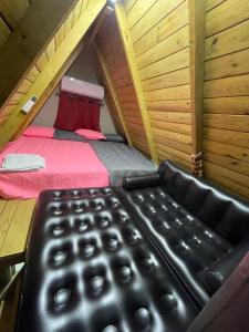 uma cadeira de couro preta num quarto com uma cama em Villa completa confotable para 9 personas em Pedernales