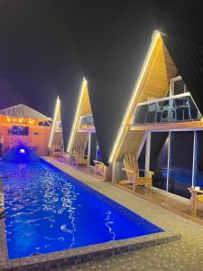 a house with a swimming pool at night at Villa completa confotable para 9 personas in Pedernales