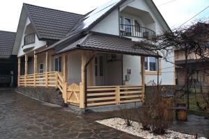 a house with a wooden porch and a balcony at La Dory in Satu Şugatag