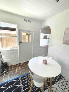 una stanza con un tavolo bianco e due sedie di Rear studio with open space a Sydney