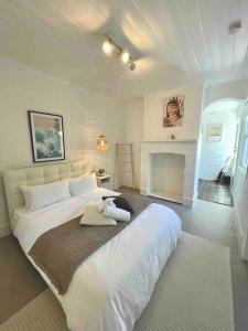 a bedroom with a large white bed and a fireplace at Rear studio with open space in Sydney